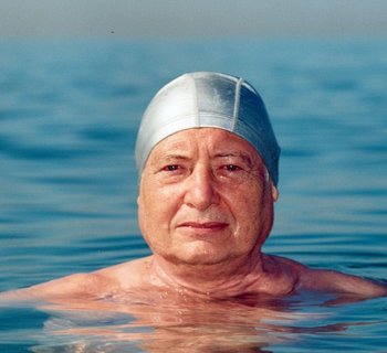 ein Mann schwimmend im Wasser mit Badekappe