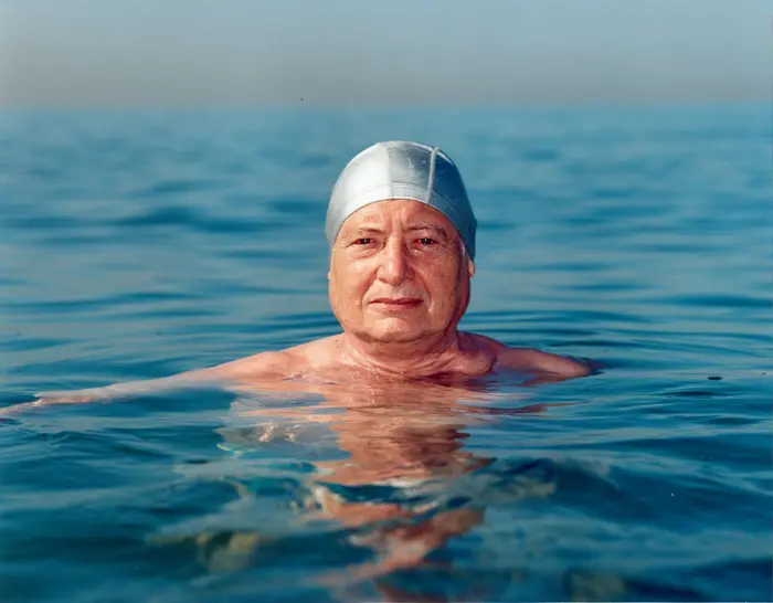 ein Mann schwimmend im Wasser mit Badekappe