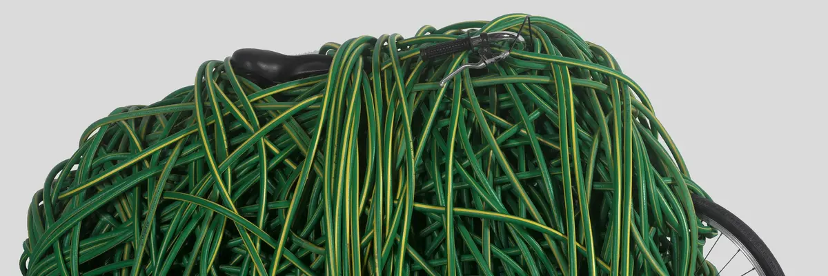 ein mit einem grünen Gartenschlauch umwickeltes Fahrrad