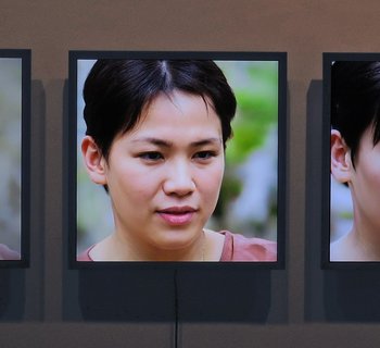 Drei parallel geschaltete quadratische Bildschirme mit Porträtfotografien
