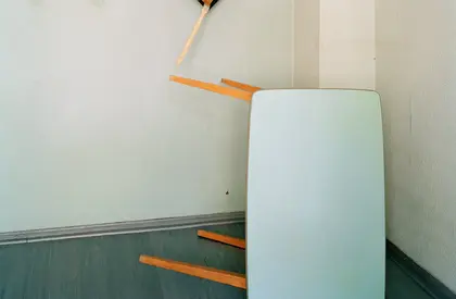 Foto mit einem umgekippten Tisch und einer Malerpalette an der Wand