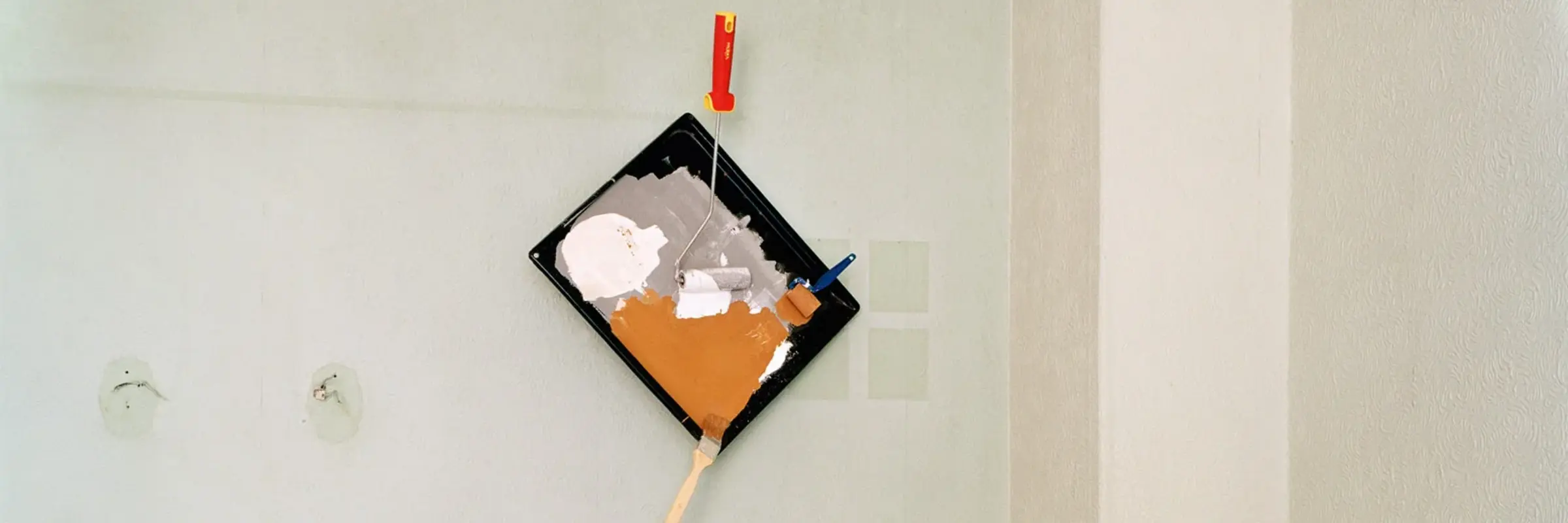 Foto mit einem umgekippten Tisch und einer Malerpalette an der Wand