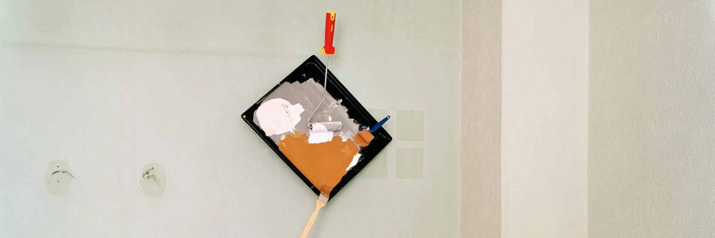 Foto mit einem umgekippten Tisch und einer Malerpalette an der Wand