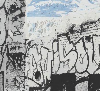 ein verfallenes, mit Graffiti beschriebenes Haus vor schneebedeckten Bergen