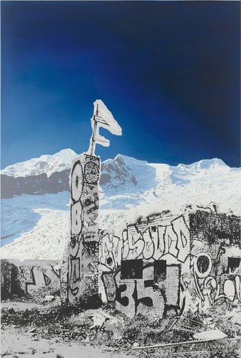ein verfallenes, mit Graffiti beschriebenes Haus vor schneebedeckten Bergen