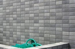 Viktoria Binschtok, grey wall (Serie Grey Cluster), 2014 Wand aus Ziegeln, in einer Einbuchtung ein Schlauch